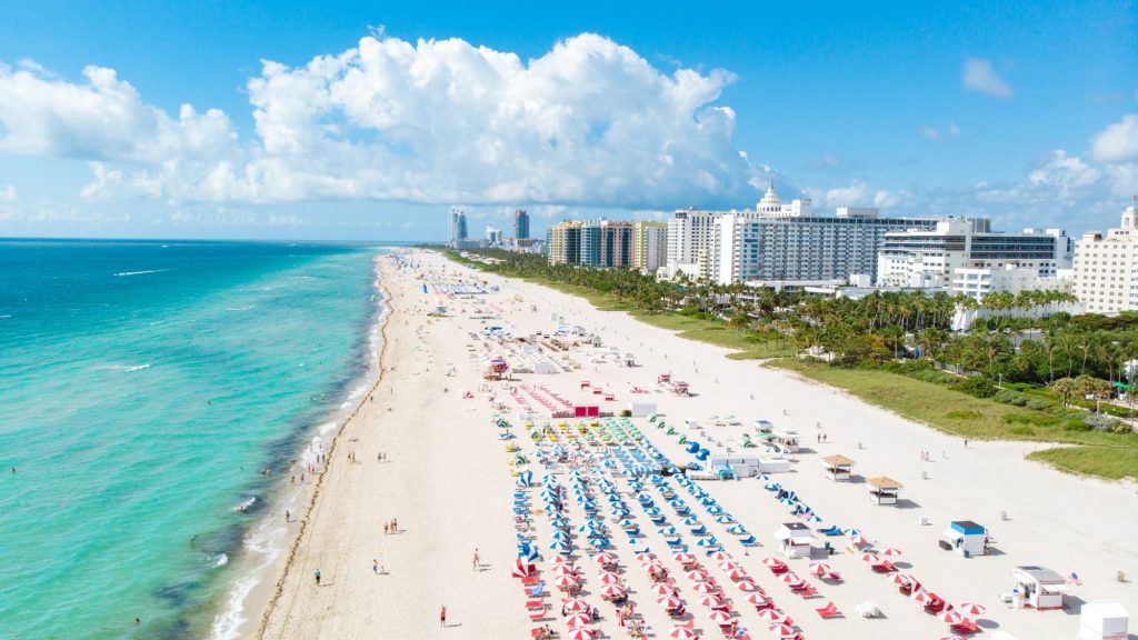 Drone aerial view at Miami South Beach Florida, Beach with colorful chairs and umbrellas